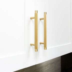 Brushed brass knurled kitchen cabinet pulls on white shaker cabinets. Potter and Clay